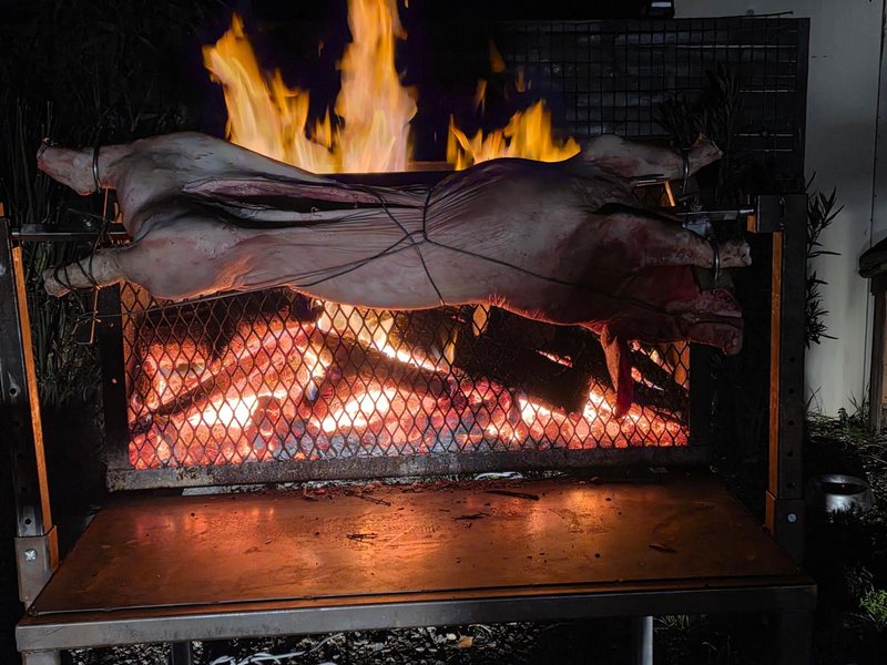 Agneau à la broche au-dessus de braises rougeoyantes