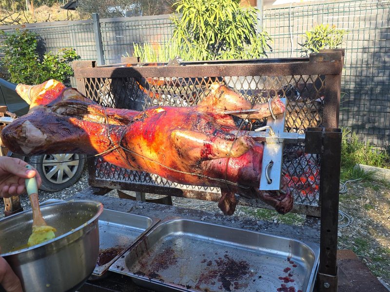 Rôtisseur arrosant le cochon pendant la cuisson à la broche